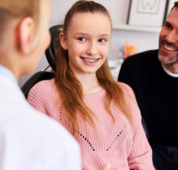 Young lady with braces and her father listening to orthodontist