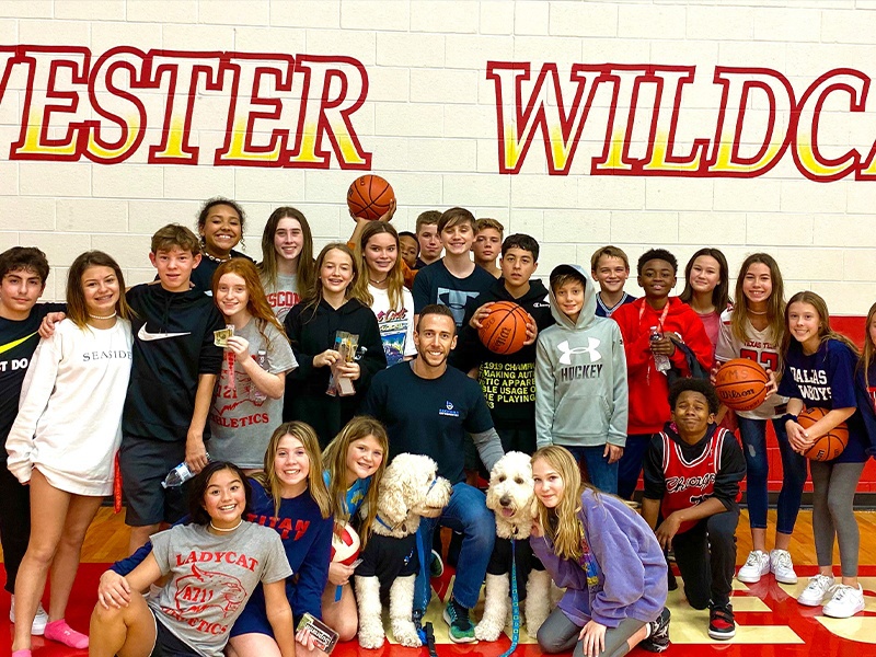 Buchwald Orthodontics team in gym with Wester Wildcats mural on wall