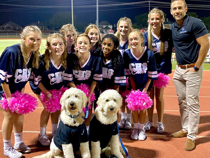 Cheerleading team with Doctor Buchwald and two dogs