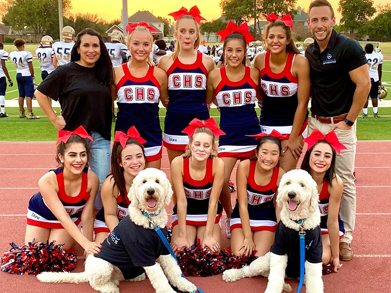 Doctor Buchwald and his two dogs with cheerleading team