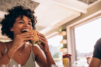 Woman smiling while eating lunch at restaurant