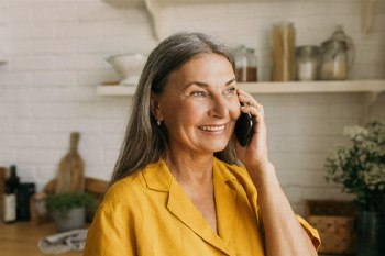 Woman smiling while talking on phone in kitchen