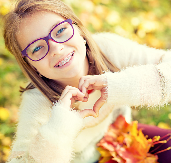 Happy preteen girl making heart shape with her hands