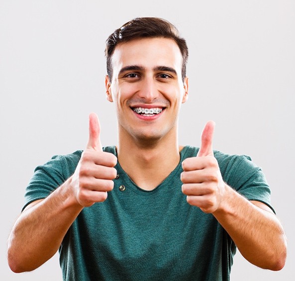 Male with braces for teens in Frisco with thumbs up