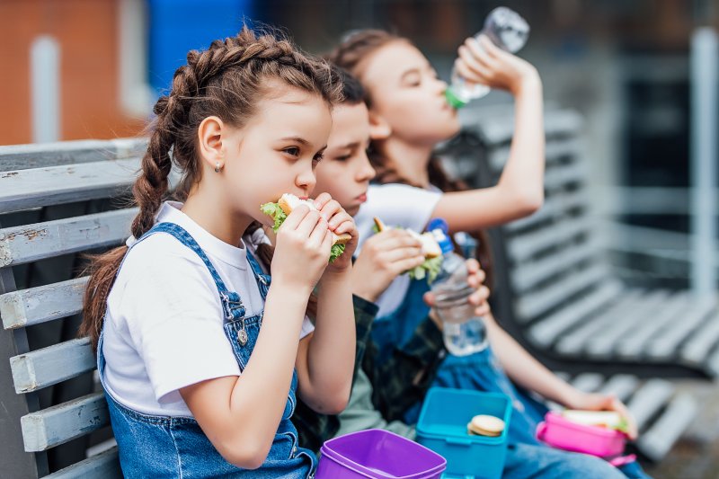 Three children eating their lunch at school