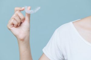 woman holding invisalign aligner